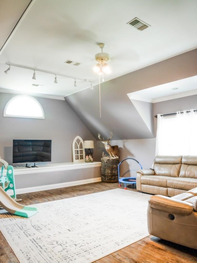 unfurnished living room with wood-type flooring, rail lighting, a wealth of natural light, and vaulted ceiling