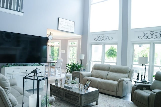 living room featuring a towering ceiling and a notable chandelier