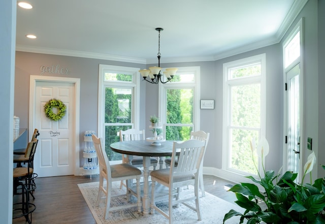 dining area with dark hardwood / wood-style floors, crown molding, and a chandelier