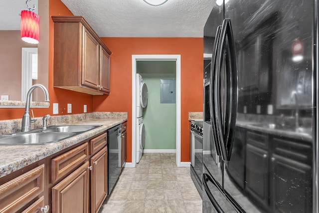 kitchen featuring a textured ceiling, black appliances, brown cabinetry, and a sink