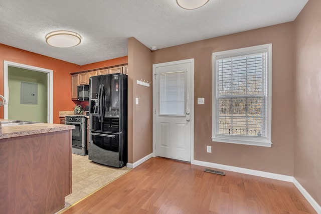 kitchen featuring visible vents, baseboards, light countertops, black appliances, and a sink