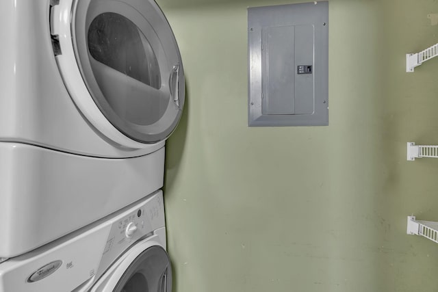 laundry room with electric panel, laundry area, and stacked washer / dryer