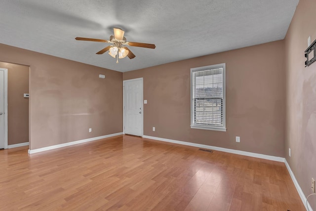 unfurnished room featuring light wood-type flooring, baseboards, a textured ceiling, and ceiling fan