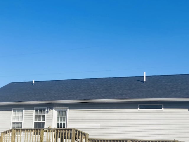 rear view of property featuring a shingled roof