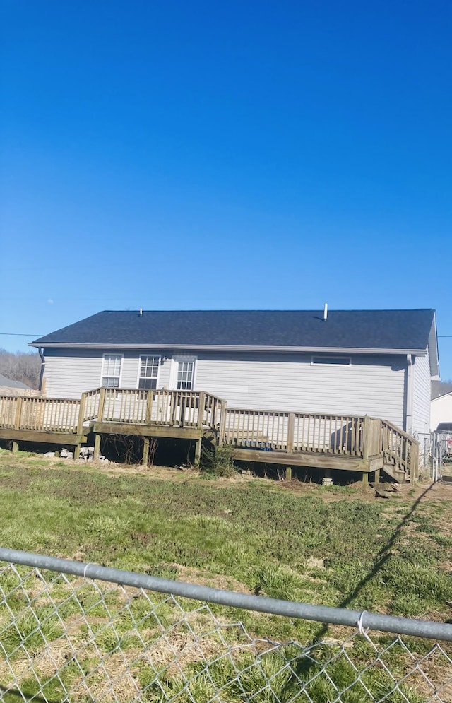 rear view of house with a deck and fence