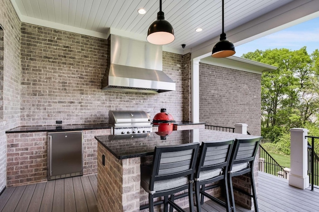 wooden terrace featuring an outdoor kitchen and a grill