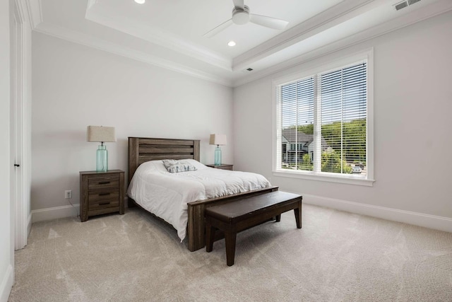 carpeted bedroom featuring ceiling fan, a raised ceiling, and crown molding