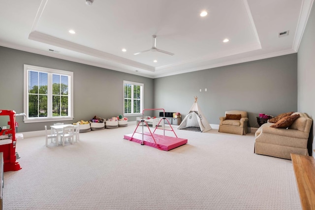 playroom featuring a raised ceiling, carpet flooring, and ornamental molding