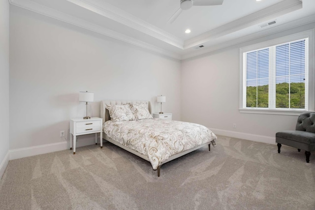 bedroom with a tray ceiling, ceiling fan, crown molding, and light colored carpet