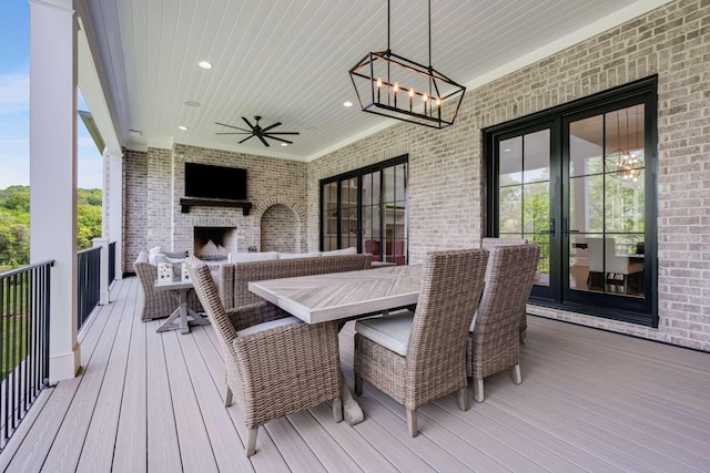 wooden terrace with french doors, an outdoor brick fireplace, and ceiling fan