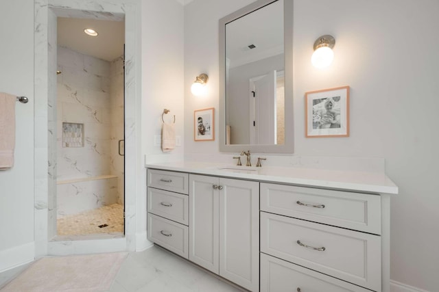 bathroom with a tile shower and vanity