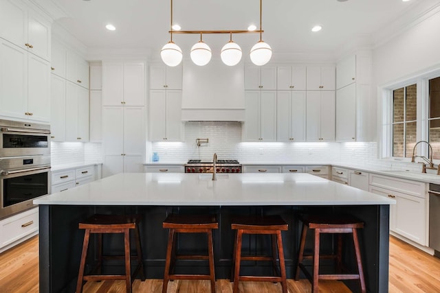 kitchen featuring a kitchen breakfast bar, sink, and an island with sink