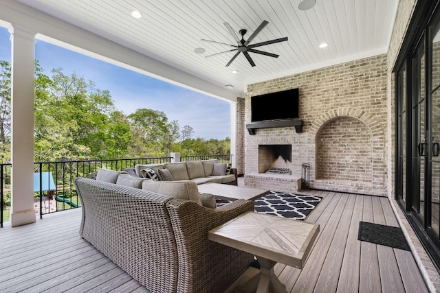 deck featuring an outdoor living space with a fireplace and ceiling fan