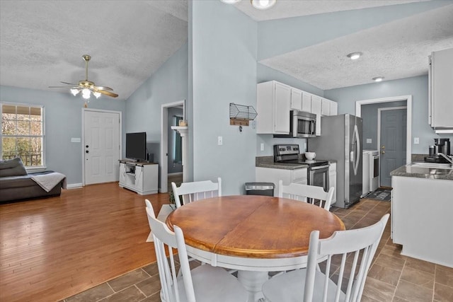 dining room with vaulted ceiling, ceiling fan, a textured ceiling, and sink