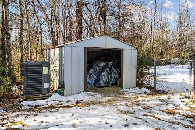 snow covered structure with central air condition unit