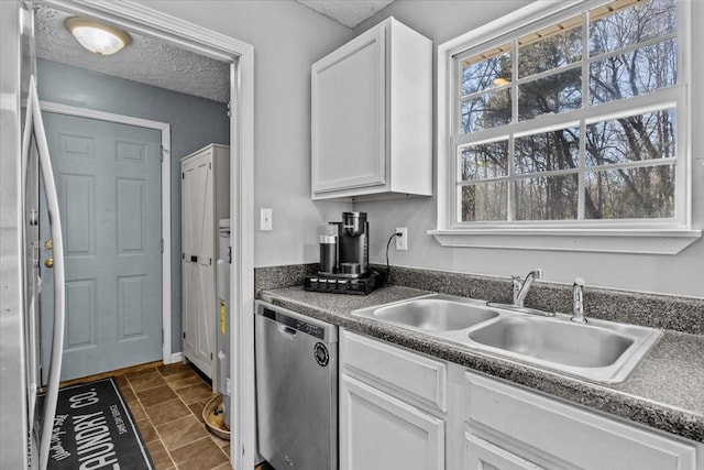 kitchen with appliances with stainless steel finishes, sink, white cabinetry, and a textured ceiling