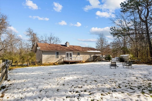 snow covered property with a deck and french doors