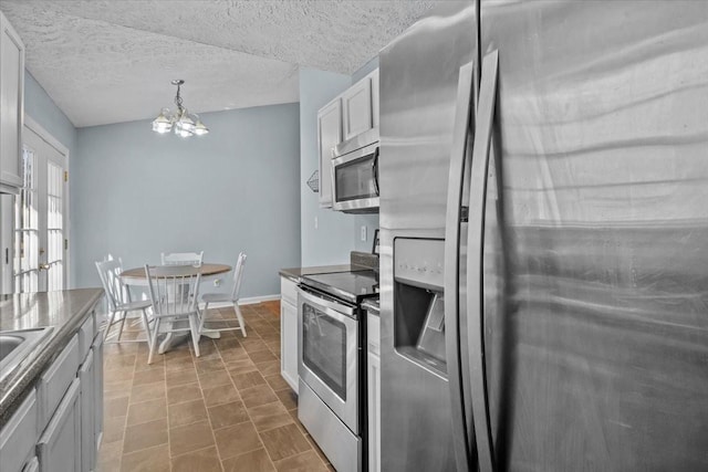 kitchen with white cabinets, a notable chandelier, stainless steel appliances, and pendant lighting