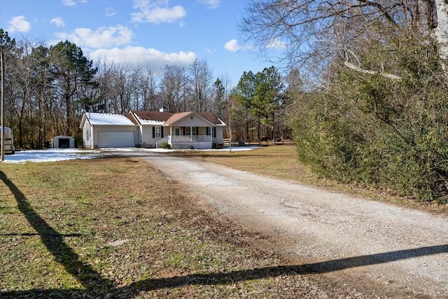 view of front of home with a front yard, covered porch, and a garage