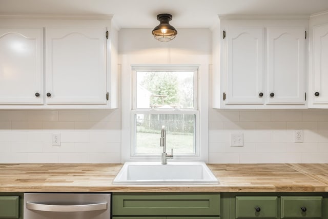 kitchen with white cabinetry, sink, green cabinets, stainless steel dishwasher, and wooden counters