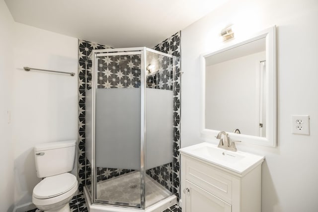 bathroom featuring tile patterned flooring, vanity, an enclosed shower, and toilet