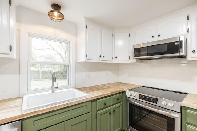 kitchen with white cabinets, appliances with stainless steel finishes, green cabinetry, and sink