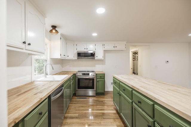 kitchen featuring sink, white cabinets, stainless steel appliances, and green cabinetry