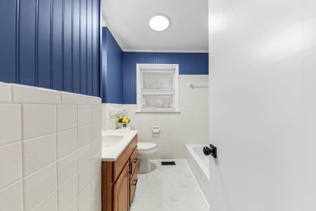 bathroom with vanity, a bath, toilet, and tile walls