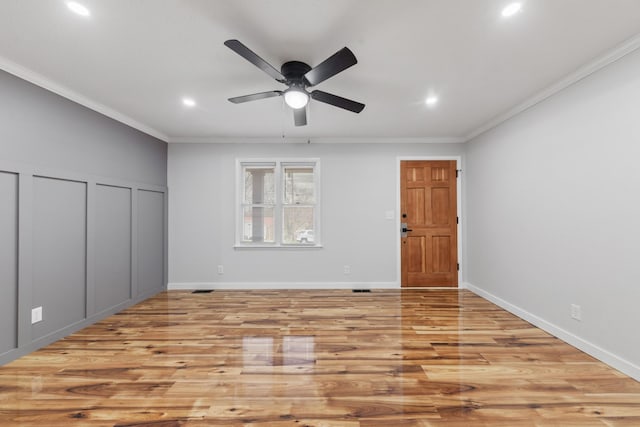 unfurnished bedroom featuring multiple closets, light wood-type flooring, ceiling fan, and crown molding