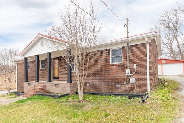 view of property exterior with covered porch, a garage, an outdoor structure, and a lawn