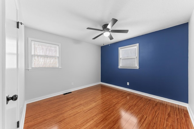 empty room featuring hardwood / wood-style floors, a textured ceiling, and ceiling fan