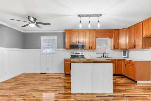 kitchen featuring crown molding, sink, stainless steel appliances, and a wealth of natural light