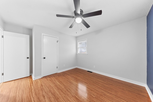 unfurnished bedroom with hardwood / wood-style floors, a closet, and ceiling fan