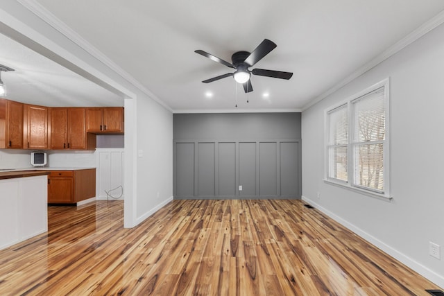 unfurnished living room with ceiling fan, light hardwood / wood-style floors, and ornamental molding