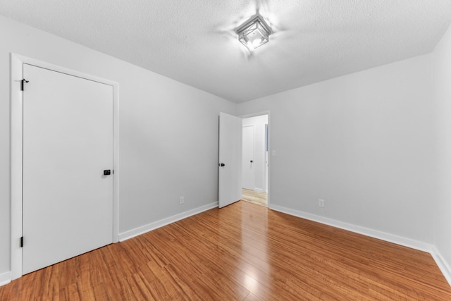 spare room with hardwood / wood-style floors and a textured ceiling