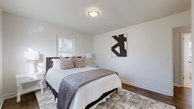 bedroom with dark hardwood / wood-style floors