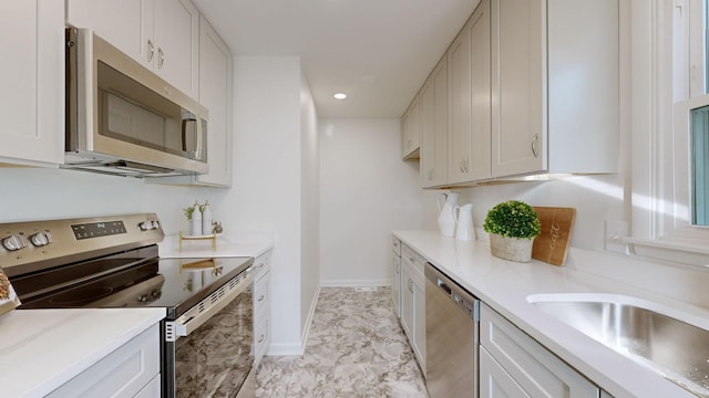 kitchen with white cabinetry, sink, and appliances with stainless steel finishes