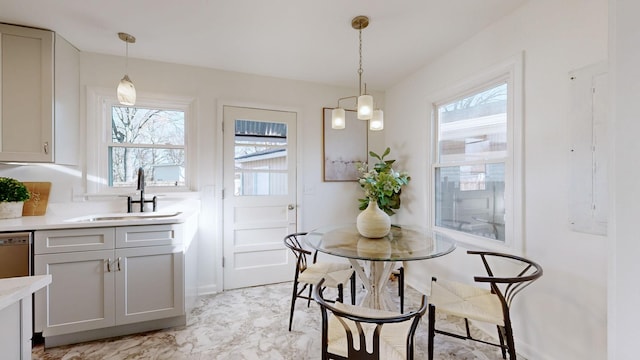 dining area with a wealth of natural light, a notable chandelier, and sink