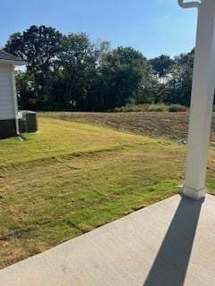 view of yard with central AC unit and a patio