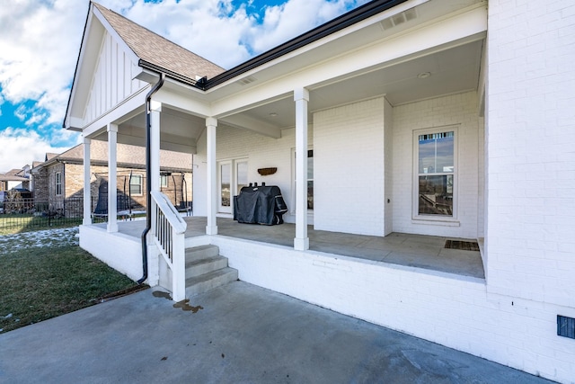 entrance to property with a yard and a patio area