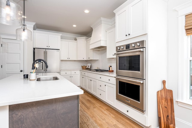 kitchen with white cabinets, appliances with stainless steel finishes, and hanging light fixtures