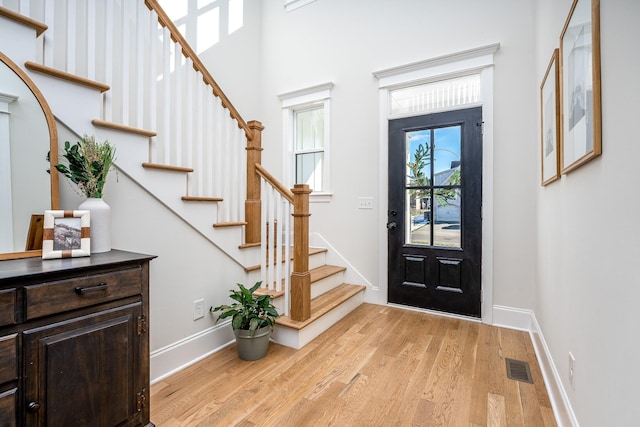 foyer featuring a towering ceiling and light hardwood / wood-style floors