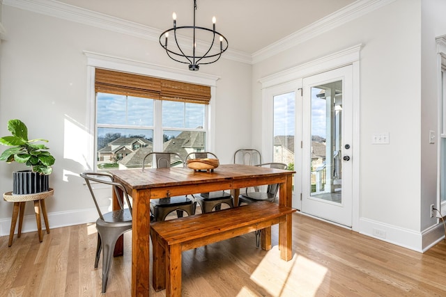 dining room with light hardwood / wood-style floors, a chandelier, and ornamental molding