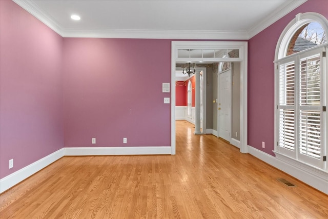 empty room with crown molding and light wood-type flooring