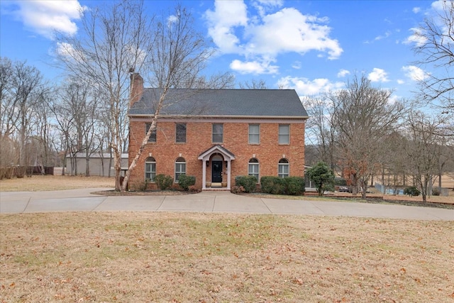 colonial inspired home featuring a front lawn