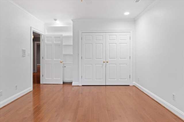 unfurnished bedroom featuring ceiling fan, ornamental molding, a closet, and light wood-type flooring