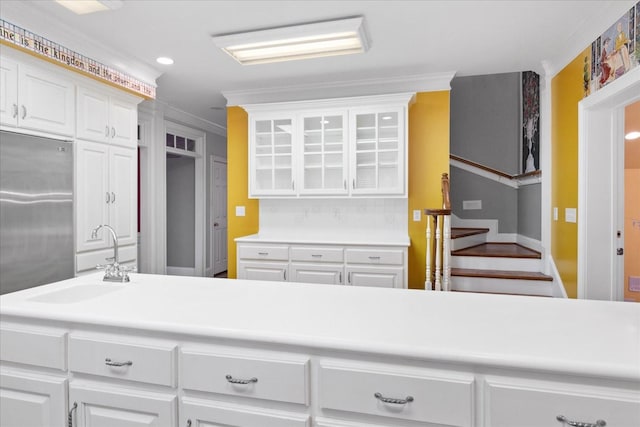 kitchen featuring crown molding, sink, and white cabinets