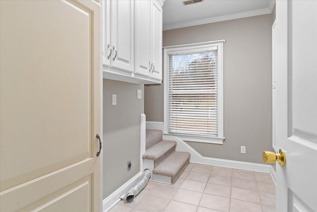 laundry room featuring crown molding, cabinets, and a wealth of natural light