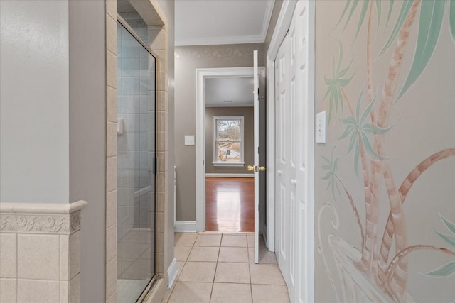 bathroom featuring ornamental molding, a shower with shower door, and tile patterned floors