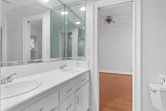 bathroom with hardwood / wood-style flooring, ornamental molding, vanity, ceiling fan, and toilet